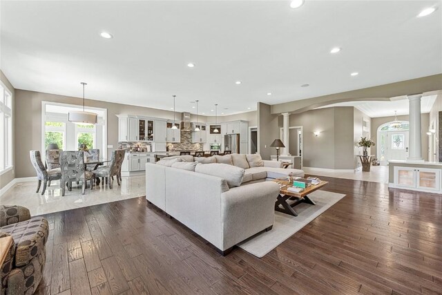 6712 Spring Grove Ct NE, Cedar Rapids, IA 52411 - living area featuring ornate columns, arched walkways, dark wood-style flooring, baseboards, and recessed lighting