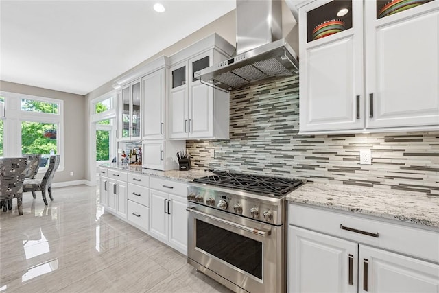 6712 Spring Grove Ct NE, Cedar Rapids, IA 52411 - kitchen with high end stove, wall chimney range hood, backsplash, white cabinets, and recessed lighting