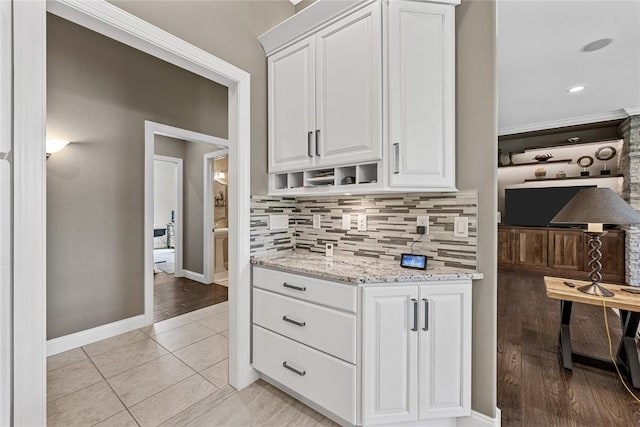 6712 Spring Grove Ct NE, Cedar Rapids, IA 52411 - kitchen with baseboards, tasteful backsplash, white cabinetry, and light stone countertops