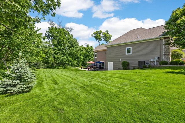 6712 Spring Grove Ct NE, Cedar Rapids, IA 52411 - view of green lawn with cooling unit and a patio area