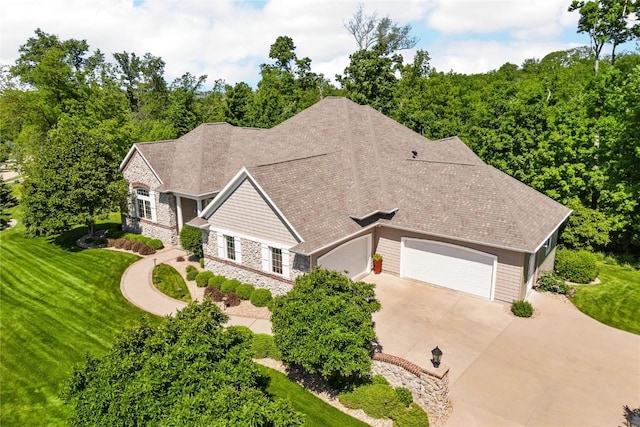 6712 Spring Grove Ct NE, Cedar Rapids, IA 52411 - view of front of property featuring concrete driveway, an attached garage, stone siding, and a front lawn