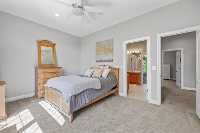 6712 Spring Grove Ct NE, Cedar Rapids, IA 52411 - bedroom with light carpet, baseboards, ensuite bath, and ceiling fan