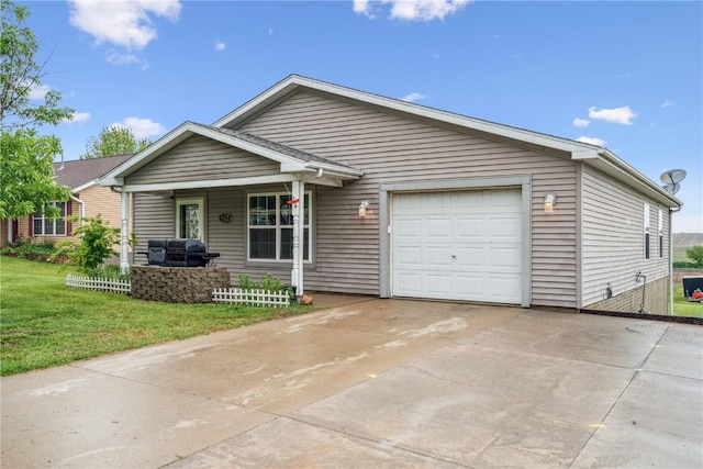 912 N St, Williamsburg, IA 52361 - view of front facade featuring covered porch, a front lawn, an attached garage, and driveway