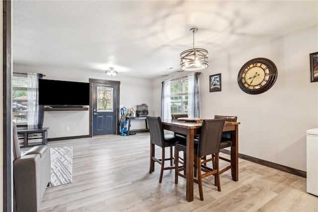 912 N St, Williamsburg, IA 52361 - dining space with light wood finished floors, baseboards, and a chandelier