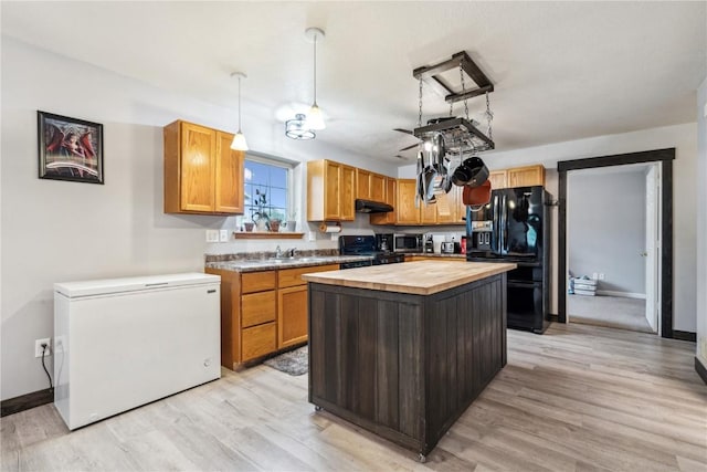 912 N St, Williamsburg, IA 52361 - kitchen featuring wooden counters, black refrigerator with ice dispenser, fridge, range, and a sink