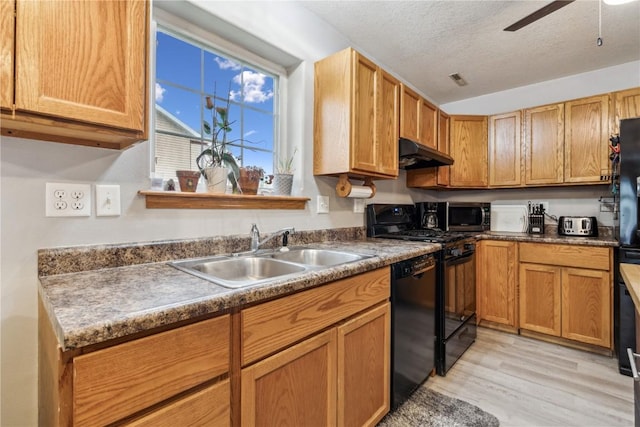 912 N St, Williamsburg, IA 52361 - kitchen featuring under cabinet range hood, a sink, black appliances, light wood-style flooring, and ceiling fan