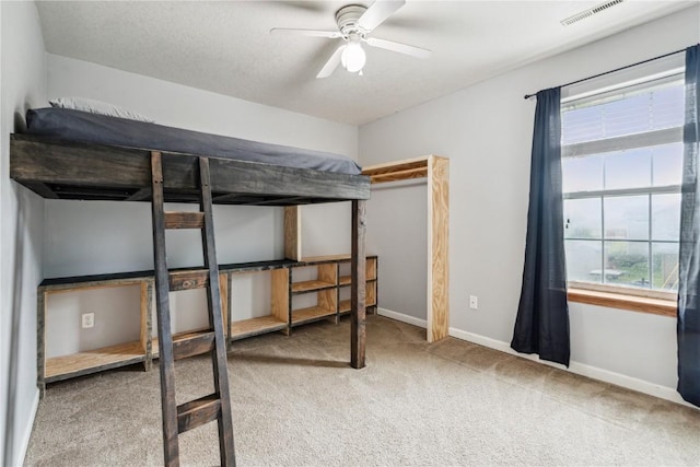 912 N St, Williamsburg, IA 52361 - unfurnished bedroom with carpet floors, multiple windows, baseboards, and a ceiling fan