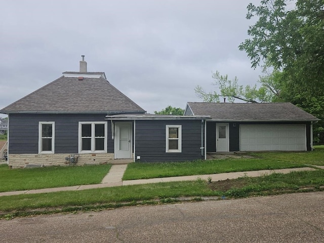 1602 11th Ave, Belle Plaine, IA 52298 - view of front of home with a chimney, a front lawn, roof with shingles, and a garage