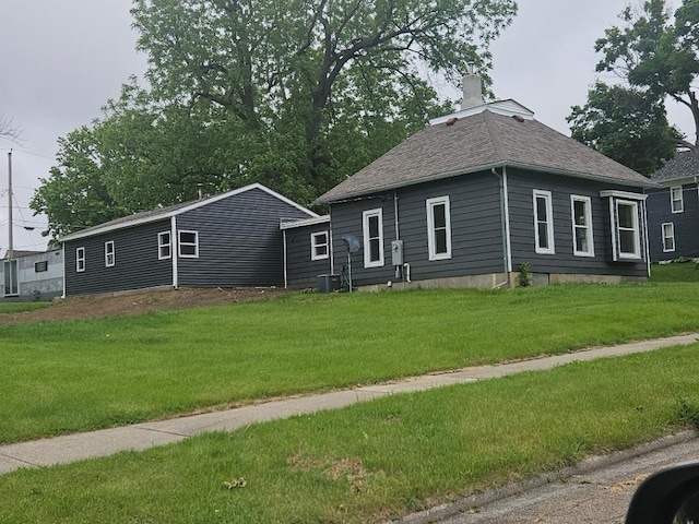 1602 11th Ave, Belle Plaine, IA 52298 - view of front facade with a chimney, a front yard, and roof with shingles