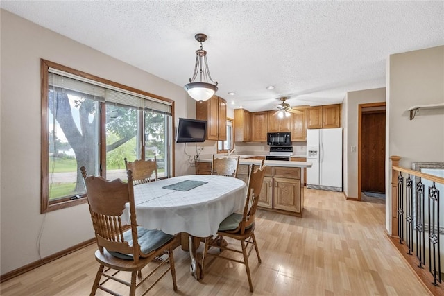 2914 Windy Ridge Rd NE, Swisher, IA 52338 - dining space with light wood finished floors, a textured ceiling, ceiling fan, and baseboards