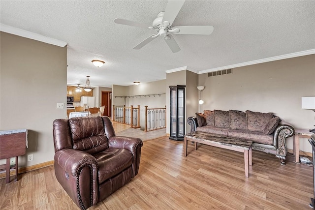 2914 Windy Ridge Rd NE, Swisher, IA 52338 - living area featuring a textured ceiling, light wood-style floors, ceiling fan, crown molding, and baseboards