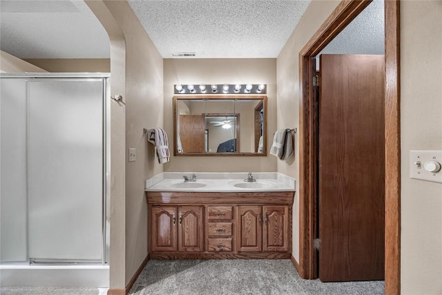 2914 Windy Ridge Rd NE, Swisher, IA 52338 - bathroom featuring a shower stall, double vanity, and a textured ceiling
