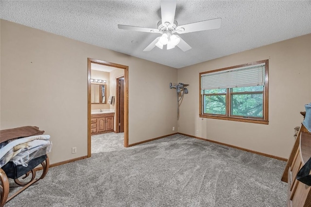 2914 Windy Ridge Rd NE, Swisher, IA 52338 - unfurnished bedroom with a textured ceiling, carpet, baseboards, ceiling fan, and ensuite bathroom