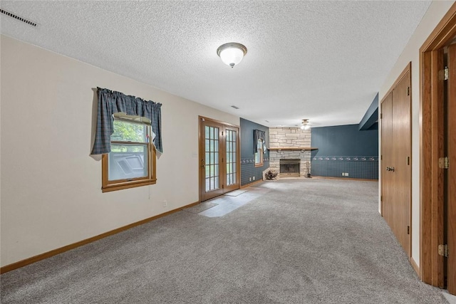 2914 Windy Ridge Rd NE, Swisher, IA 52338 - unfurnished living room with a fireplace, carpet flooring, a textured ceiling, and baseboards