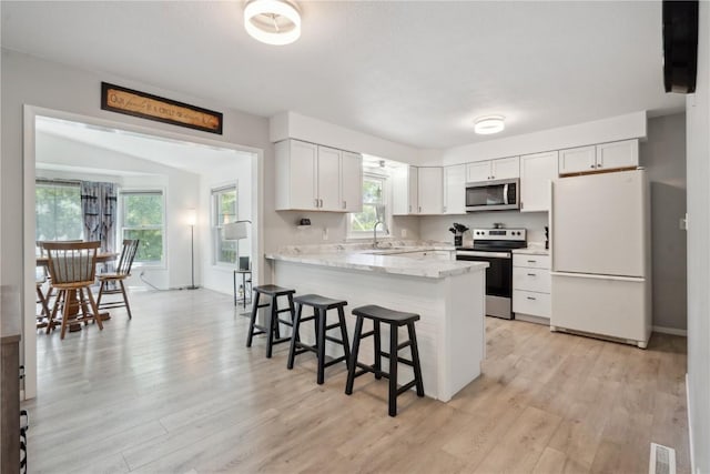 75 Jefferson Ave SW, Swisher, IA 52238 - kitchen featuring stainless steel appliances, a peninsula, a breakfast bar area, and light wood finished floors