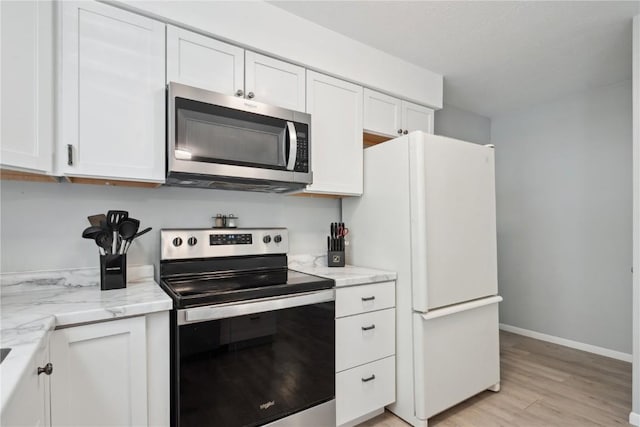 75 Jefferson Ave SW, Swisher, IA 52238 - kitchen with appliances with stainless steel finishes, light wood finished floors, white cabinets, baseboards, and light stone counters