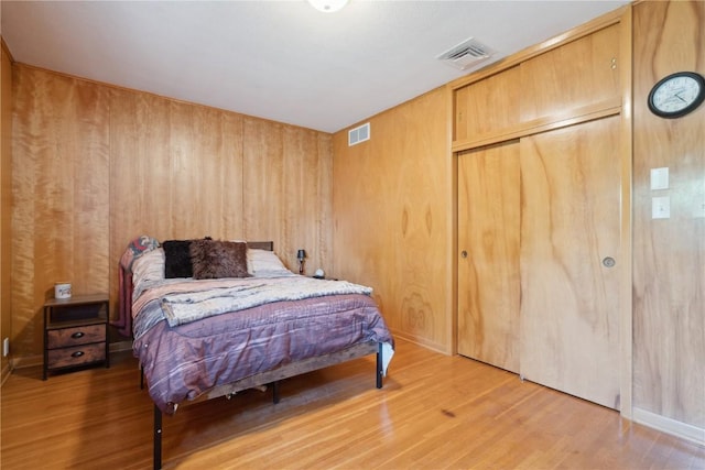 75 Jefferson Ave SW, Swisher, IA 52238 - bedroom featuring light wood-style flooring, a closet, and wooden walls