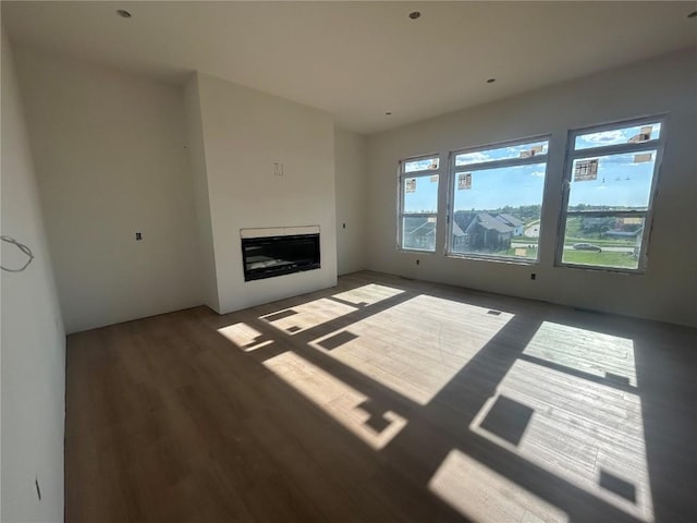 1205 Croell Ave, Tiffin, IA 52340 - unfurnished living room featuring wood finished floors, a glass covered fireplace, and heating unit