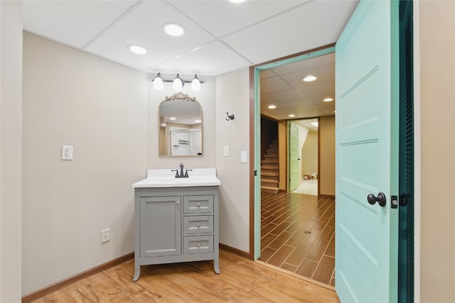 1206 W State St, Williamsburg, IA 52361 - bathroom featuring wood finished floors, vanity, baseboards, and recessed lighting