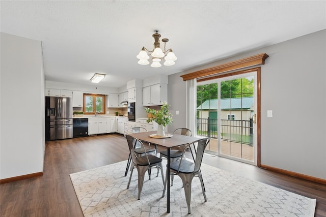 1206 W State St, Williamsburg, IA 52361 - dining space with a chandelier, baseboards, and dark wood-style floors