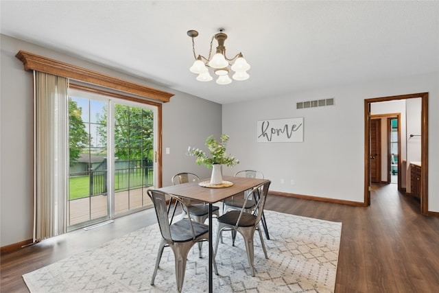 1206 W State St, Williamsburg, IA 52361 - dining area with a chandelier, dark wood-type flooring, and baseboards