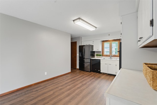 1206 W State St, Williamsburg, IA 52361 - kitchen featuring black appliances, a sink, dark wood-style flooring, and light countertops