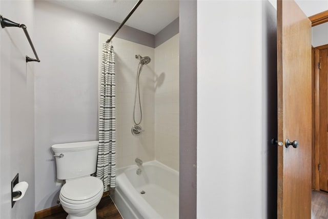 1206 W State St, Williamsburg, IA 52361 - full bath featuring shower / bathtub combination with curtain, toilet, wood finished floors, and baseboards