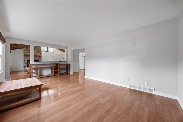 1220 Northwood Ln, Muscatine, IA 52761 - unfurnished living room featuring light wood-type flooring, baseboards, and a fireplace