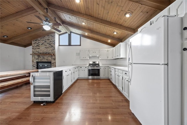 1220 Northwood Ln, Muscatine, IA 52761 - kitchen with freestanding refrigerator, stainless steel gas range oven, ceiling fan, wine cooler, and wood finished floors