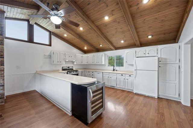 1220 Northwood Ln, Muscatine, IA 52761 - kitchen with white appliances, wooden ceiling with exposed beams, beverage cooler, under cabinet range hood, and a peninsula