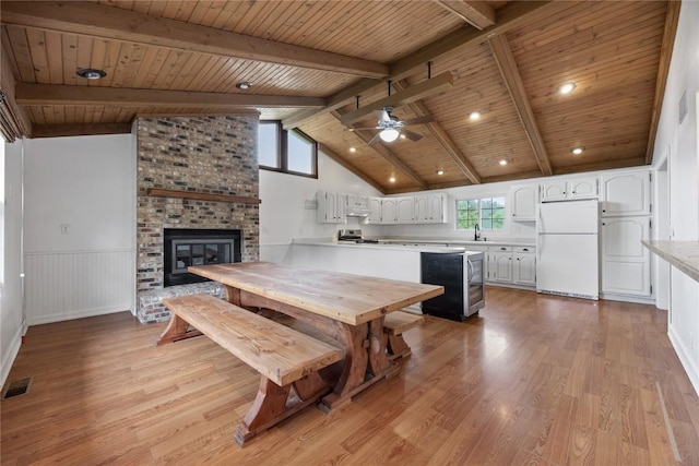 1220 Northwood Ln, Muscatine, IA 52761 - dining area with wood ceiling, a ceiling fan, a brick fireplace, light wood finished floors, and wainscoting