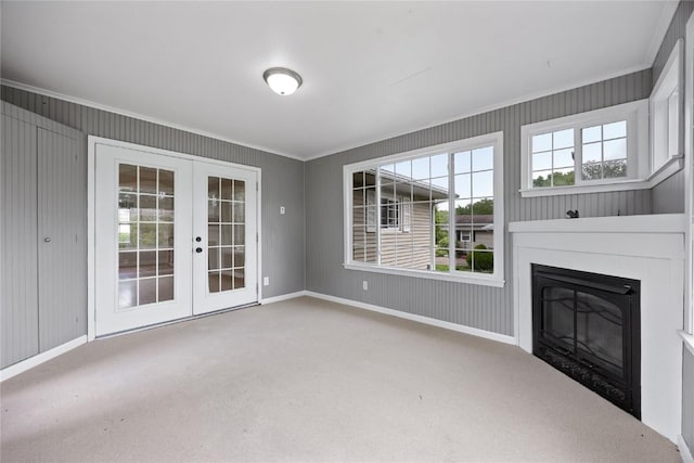 1220 Northwood Ln, Muscatine, IA 52761 - unfurnished living room featuring carpet, ornamental molding, french doors, healthy amount of natural light, and a glass covered fireplace