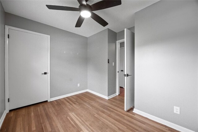 1220 Northwood Ln, Muscatine, IA 52761 - unfurnished bedroom featuring wood finished floors, baseboards, and a ceiling fan