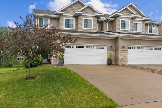 1225 Daisy Cir, North Liberty, IA 52317 - view of front of house featuring concrete driveway, an attached garage, a front yard, and stone siding