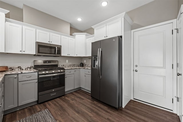 1225 Daisy Cir, North Liberty, IA 52317 - kitchen with appliances with stainless steel finishes, dark wood-style flooring, light stone countertops, gray cabinets, and recessed lighting