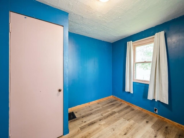 259 25th Ave SW, Cedar Rapids, IA 52404 - empty room with wood finished floors, baseboards, and a textured ceiling