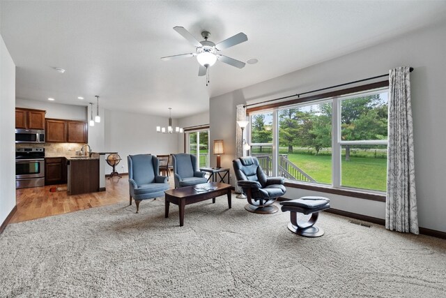 2913 Caspian Rd, Hiawatha, IA 52233 - living room featuring ceiling fan, a chandelier, light wood-type flooring, recessed lighting, and light carpet