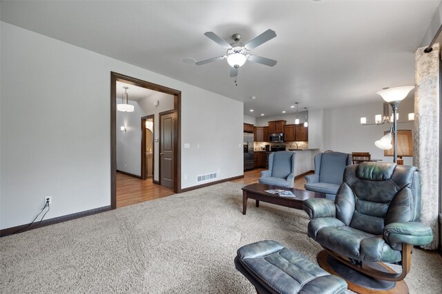 2913 Caspian Rd, Hiawatha, IA 52233 - living room featuring light carpet, a ceiling fan, and baseboards