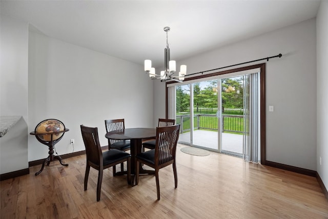 2913 Caspian Rd, Hiawatha, IA 52233 - dining space featuring a chandelier, light wood-style floors, and baseboards