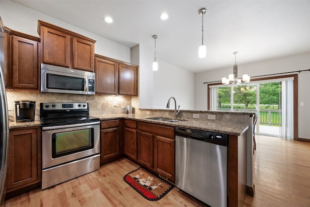 2913 Caspian Rd, Hiawatha, IA 52233 - kitchen with appliances with stainless steel finishes, a sink, backsplash, light wood-style floors, and a peninsula