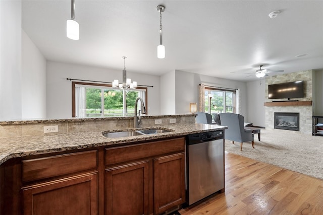 2913 Caspian Rd, Hiawatha, IA 52233 - kitchen with dishwasher, a sink, a fireplace, ceiling fan, and light stone counters