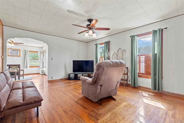 405 6th Ave, Clarence, IA 52216 - living room featuring a ceiling fan, arched walkways, a wall unit AC, and light wood finished floors