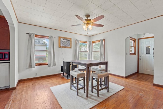 405 6th Ave, Clarence, IA 52216 - dining room featuring arched walkways, an AC wall unit, plenty of natural light, and light wood-type flooring