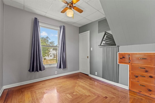 405 6th Ave, Clarence, IA 52216 - unfurnished bedroom with baseboards, a paneled ceiling, and a ceiling fan