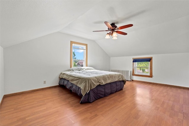 405 6th Ave, Clarence, IA 52216 - bedroom with radiator, vaulted ceiling, wood finished floors, a ceiling fan, and baseboards