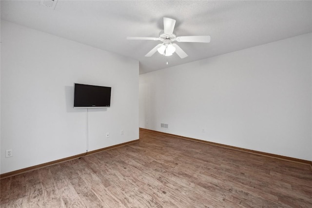 80 Florence Way, North Liberty, IA 52317 - unfurnished room with wood finished floors, a ceiling fan, and baseboards