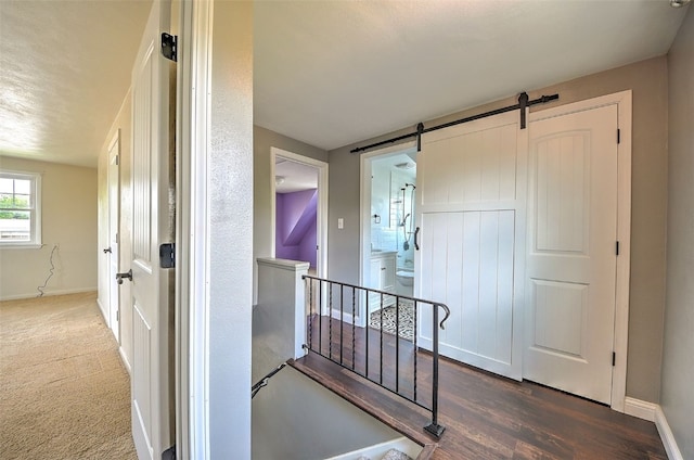 1139 H Ave NE, Cedar Rapids, IA 52402 - hall with baseboards, an upstairs landing, wood finished floors, and a barn door
