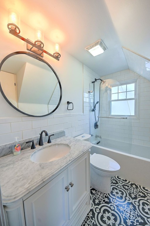 1139 H Ave NE, Cedar Rapids, IA 52402 - bathroom with tile walls, vanity, toilet, shower / washtub combination, and tile patterned flooring