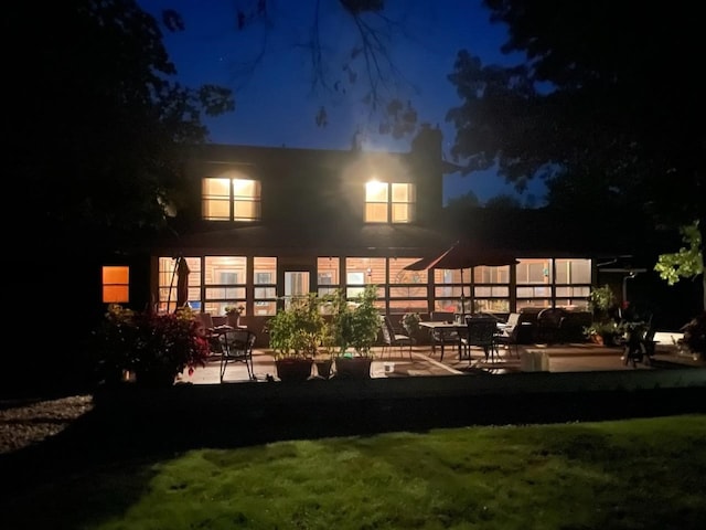 1901 42nd St SE, Cedar Rapids, IA 52403 - back of house at twilight featuring a patio area