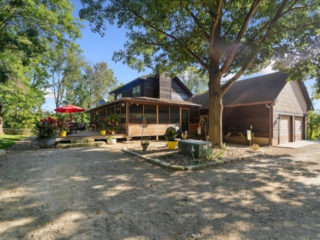 1901 42nd St SE, Cedar Rapids, IA 52403 - view of front of house featuring a sunroom, a chimney, a deck, and roof with shingles